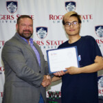 Hawken Grubbs, instructor of technology and justice studies, congratulated students on their outstanding showing in the National Cyber League Competition. A smiling male professor congratulates a student